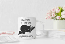 Lade das Bild in den Galerie-Viewer, Ein humorvolles Bild einer Tasse mit dem Schriftzug 'Irgendwas ist hier faul. Oh, das bin ja ich.' und einem gemütlichen Faultier, das auf einem Ast liegt. Das Bild strahlt Entspannung und humorvolle Selbstreflexion aus.